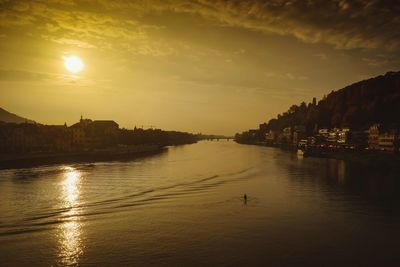 Scenic view of river against sky at sunset