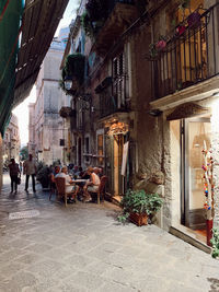 People on street amidst buildings in city