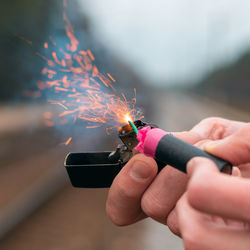 Close-up of hand holding sparkler against blurred background
