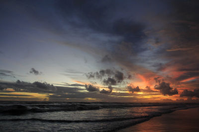 Scenic view of sea against dramatic sky during sunset