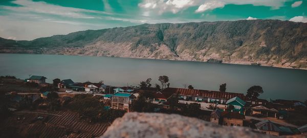 High angle view of townscape by lake against sky