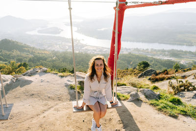 Young woman on a swing against a beautiful landscape in galicia, spain