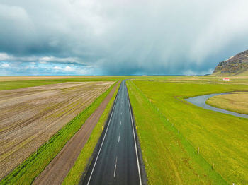 Endless road into the cloudy mountains and hills of iceland during sunny cloudy weather.