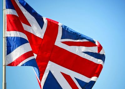 Low angle view of flag against clear blue sky