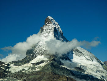 Scenic view of snowcapped mountains against clear blue sky