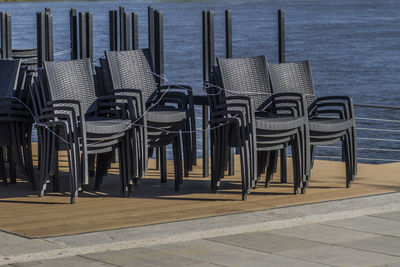 Chairs and table at beach against sky