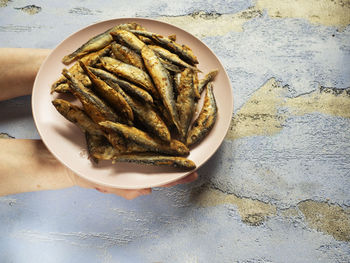 High angle view of hand holding bread on table