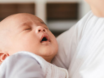 Close-up of baby boy lying on bed at home