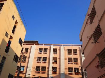 Low angle view of buildings against clear blue sky