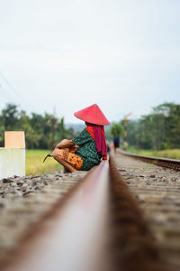 Surface level of person on railroad track against sky