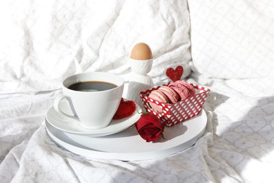 Close-up of coffee cup and breakfast on bed