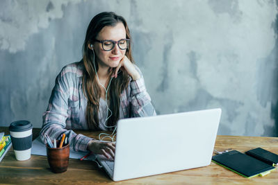 Young woman using laptop on table