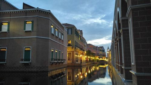 Reflection of illuminated buildings in canal at dusk
