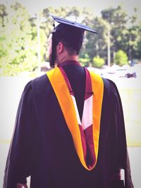Rear view of man in graduation gown