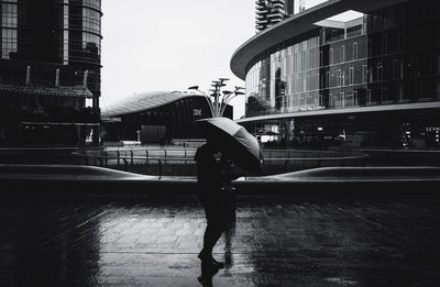 Side view of man standing on street in city