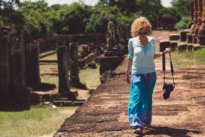 Woman carrying camera at old ruin