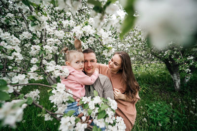 Family mom mom baby daughter in the garden blooming apple trees