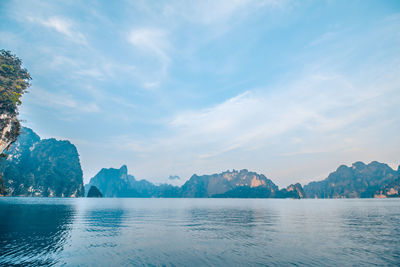 Panoramic view of sea by mountains against sky