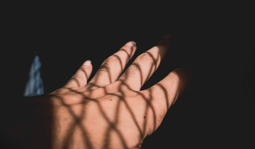 Close-up of human hand against black background