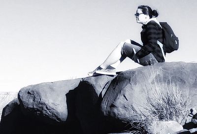 Man standing on rock against sky during winter