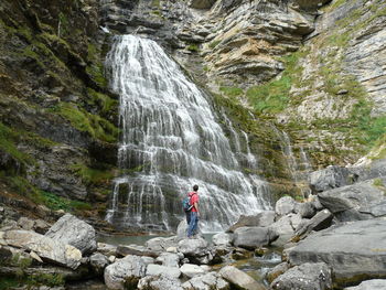 Scenic view of waterfall in mountains