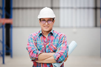 Portrait of smiling boy standing against wall