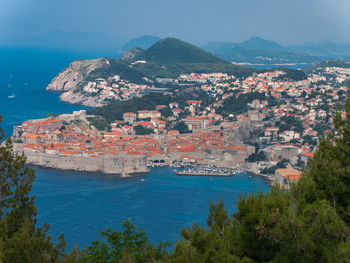 High angle view of cityscape by sea against sky