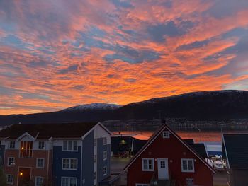 Houses in town against sky during sunset