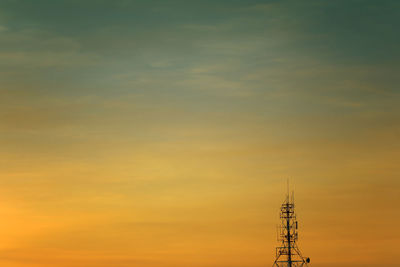 Low angle view of communications tower against sky during sunset