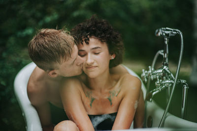 Full length of shirtless boy looking at water