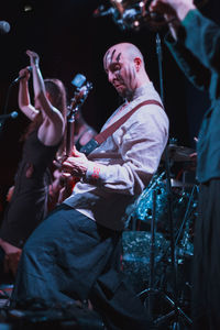 Man playing guitar on stage at music concert