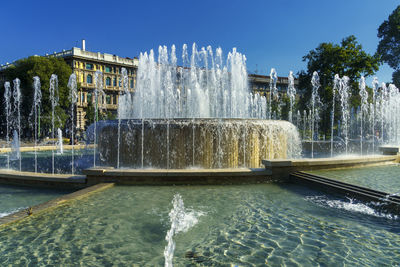 Fountain in front of built structure against sky