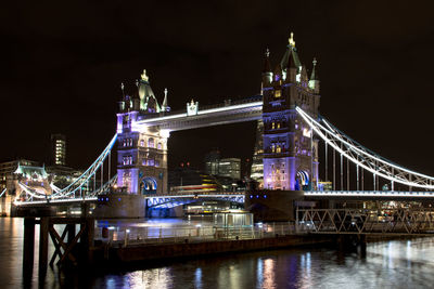 Illuminated tower bridge by river thames at night