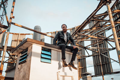 Low angle view of young man against built structure