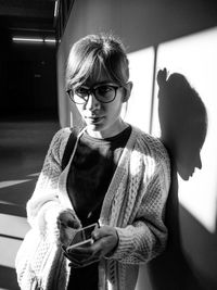 Portrait of young woman standing in hallway