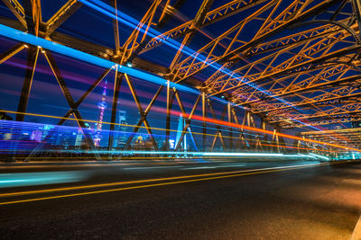 Illuminated light trails on road in city at night