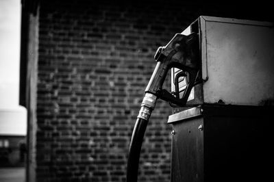 Petrol pump against brick wall