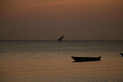 Silhouette boat on sea against sky during sunset