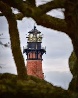 Low angle view of currituck lighthouse against sky through the trees 