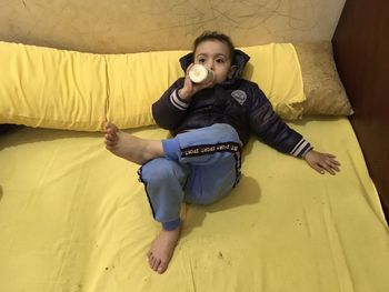 Portrait of boy lying on bed at home