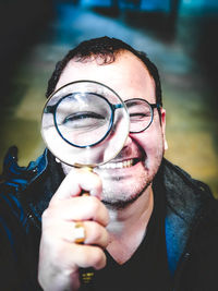 Portrait of young man holding eyeglasses