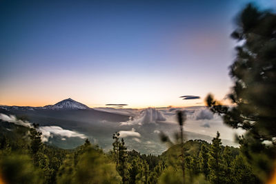 Scenic view of mountains against clear sky at sunset