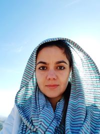 Portrait of beautiful young woman against clear blue sky