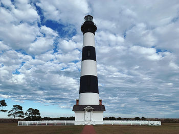 Low angle view of bodie island lighthouse against cloudy sky. cape hatteras national seashore