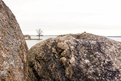 Rock in sea against sky