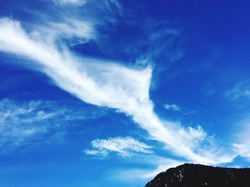 Low angle view of vapor trail against blue sky