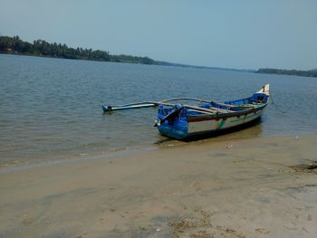 Boat moored on sea against sky