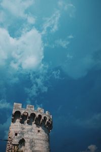 Low angle view of old building against cloudy sky