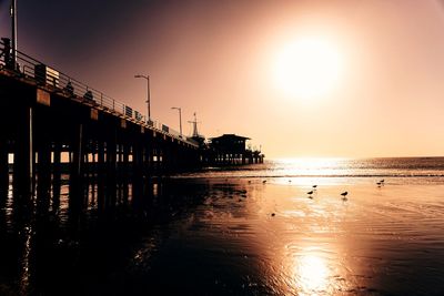 Silhouette pier on sea against sky during sunset