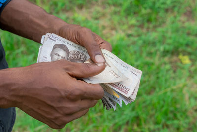 Midsection of man holding paper on field
